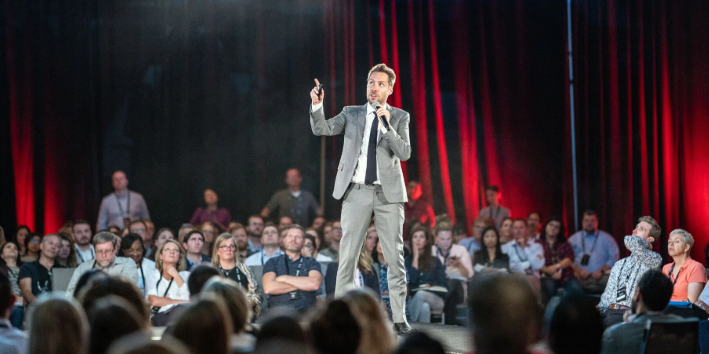 Jeremy Gutsche speaking on stage to a packed audience